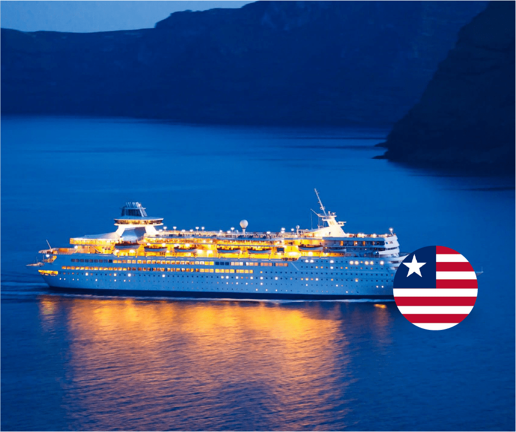 Illuminated cruise ship in blue water with cliffs, representing Liberia-approved STCW Crisis Management and Human Behavior maritime training course