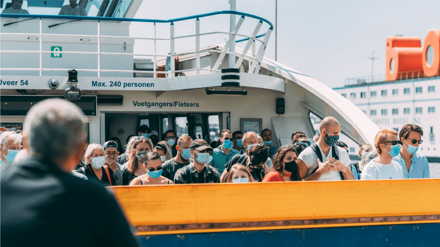 Maritime crew members gather on ferry deck during crowd management training, demonstrating emergency procedures for handling large passenger groups on commercial vessels