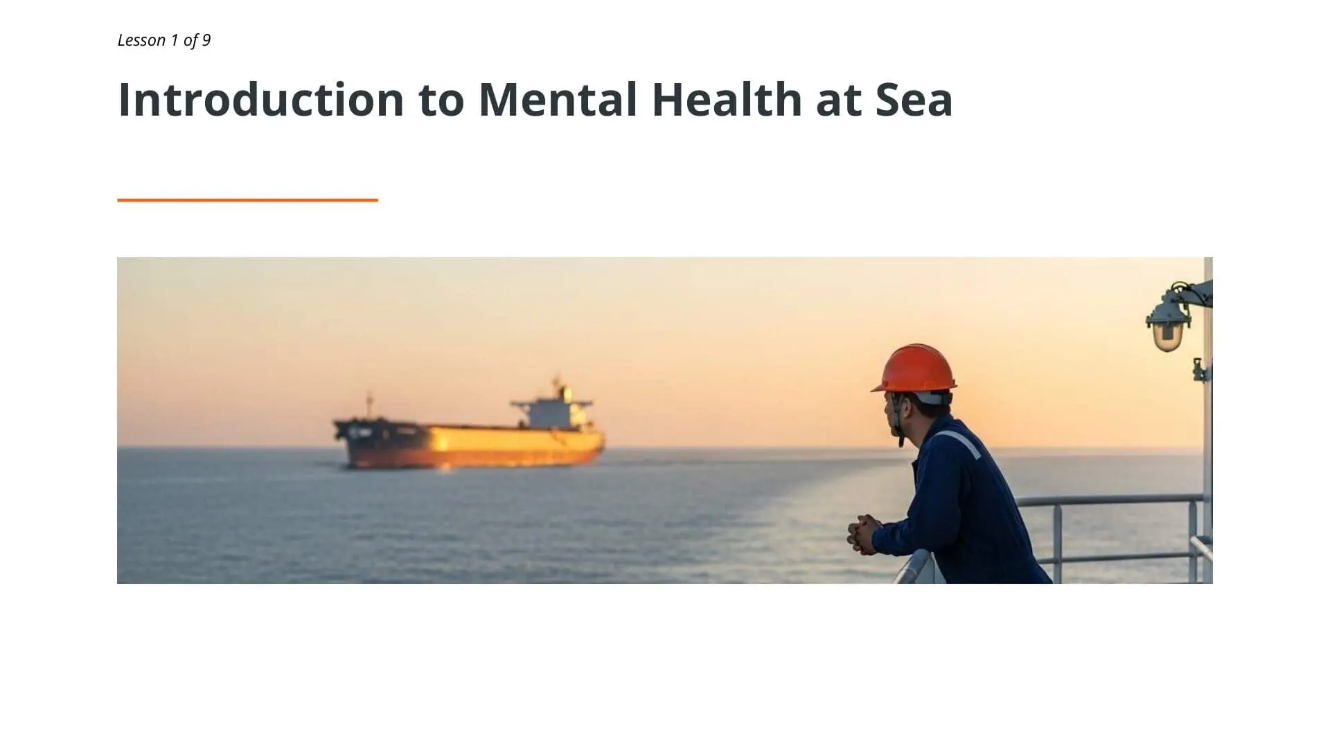 Seafarer in red hard hat observing ship at sunset, representing mental health awareness training for maritime workers