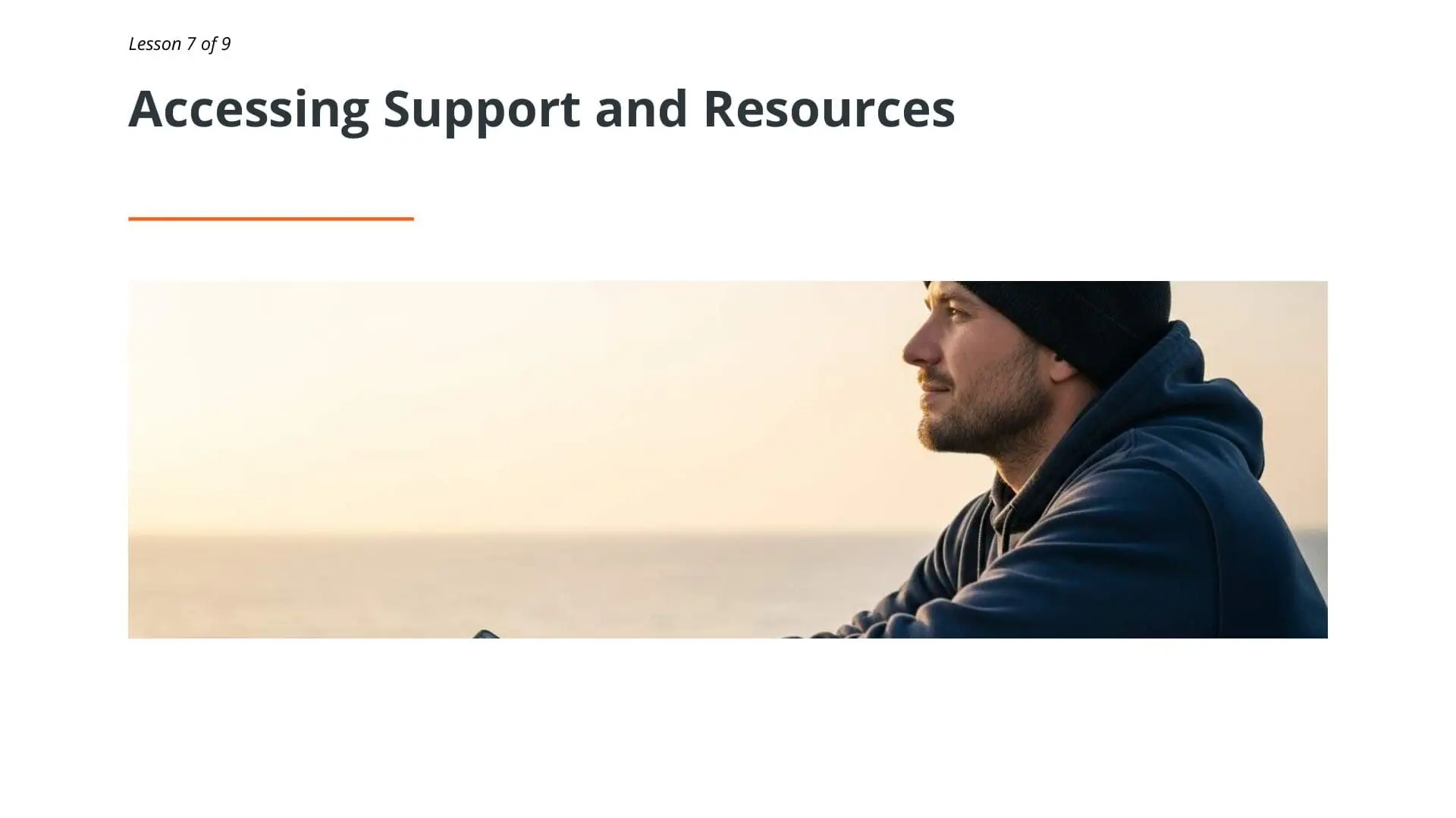 Man in blue hoodie looking toward horizon at sunset, representing mental health awareness and support resources for maritime professionals