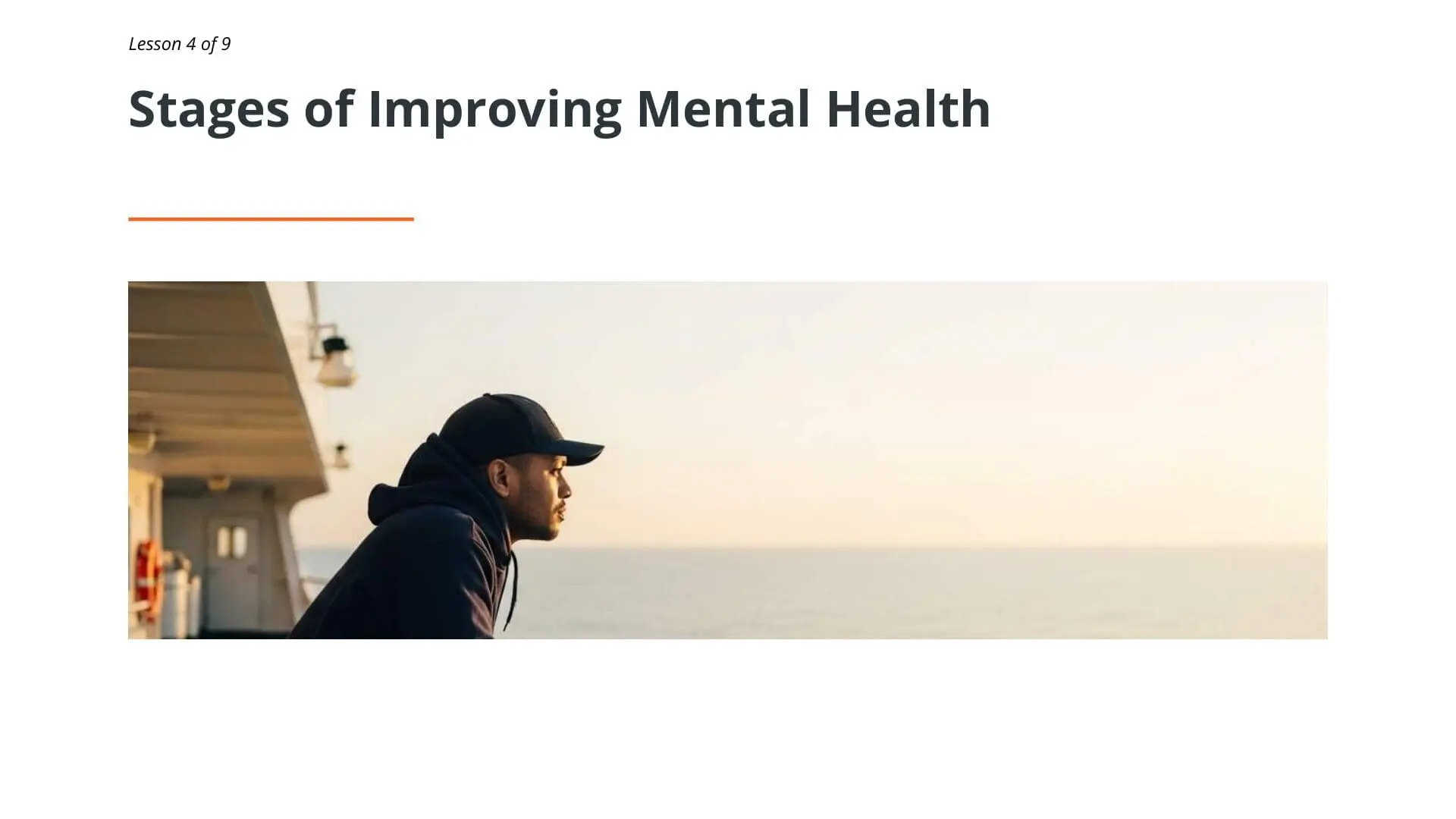 Seafarer in cap looking at ocean horizon, representing mental health awareness and wellbeing for maritime professionals