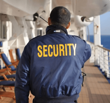 Security professional in navy jacket patrolling maritime vessel deck for online maritime training