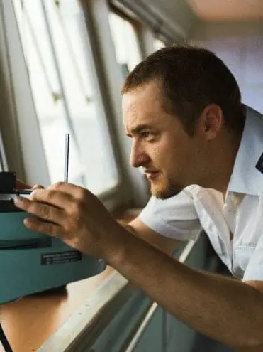 Man at desk using wireless technology for STCW maritime training course on computer