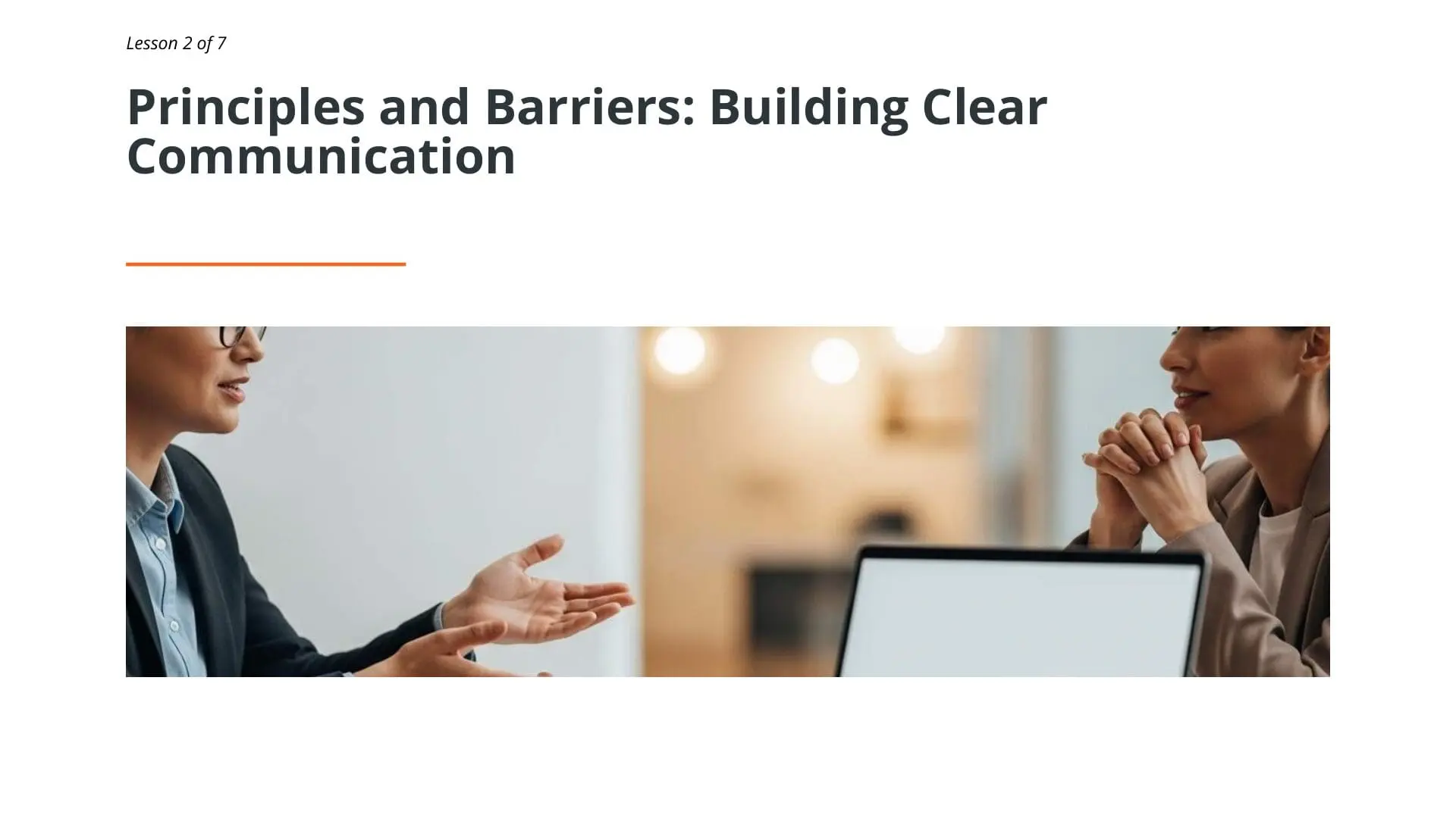 Two maritime professionals collaborating at laptop, demonstrating clear communication principles for effective workplace relationships and professional development