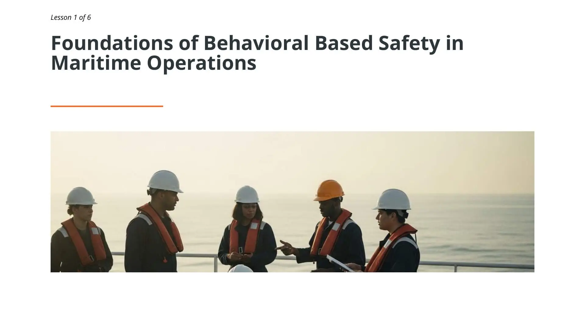 Five maritime workers wearing hard hats and life vests discuss safety procedures on ship deck during behavioral based safety training lesson