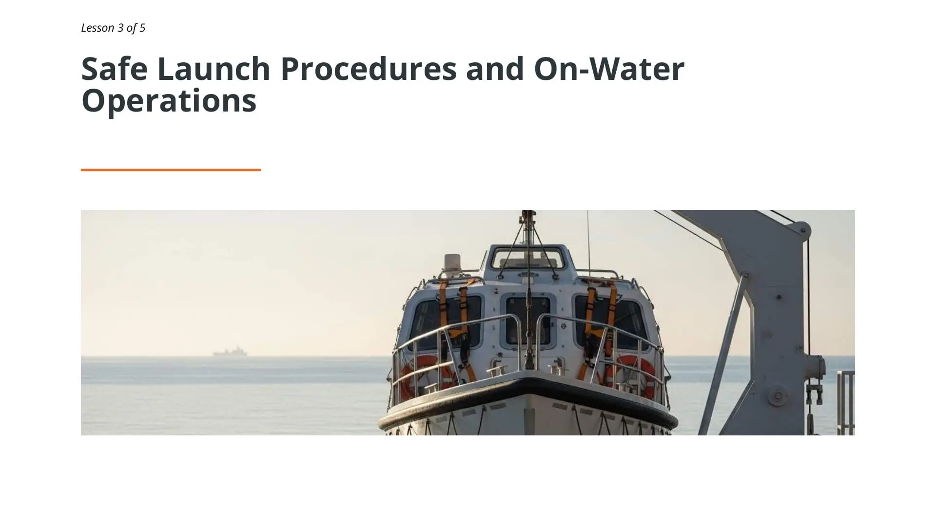 Lifeboat davit system with vessel positioned at water's edge during free-fall lifeboat operations training for maritime emergency response