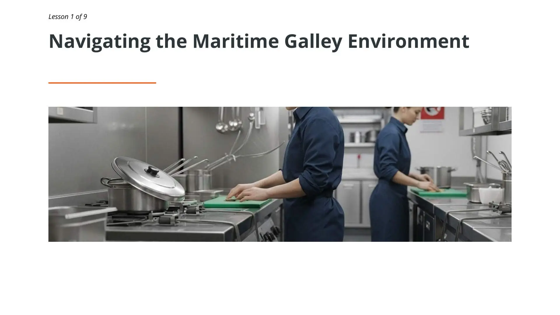 Two maritime crew members in blue uniforms working in a ship's galley kitchen with stainless steel equipment and cooking stations during STCW safety training