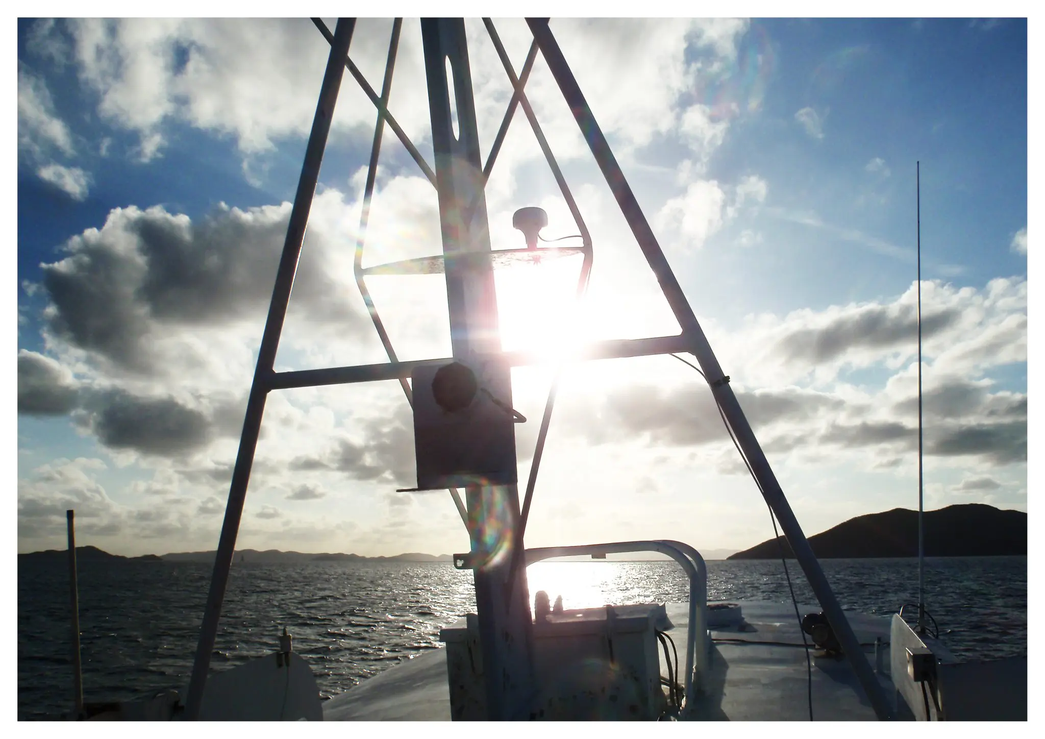 Boat crew member on fishing vessel with sun and ocean backdrop, maritime training and navigation